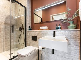 A bathroom with a shower, sink, and toilet at Hidden 10- Godrevy View, St Ives