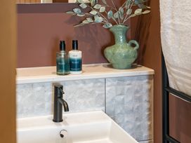 A bathroom with a sink and toiletries at Hidden 10- Godrevy View St Ives