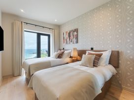 A bedroom with twin beds and a window view at Hidden 10- Godrevy View in St Ives