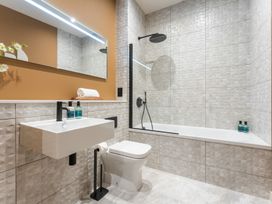A bathroom with a bathtub and sink at Hidden 10- Godrevy View in St Ives