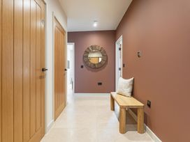 A hallway with a mirror and a bench at Hidden 10- Godrevy View St Ives