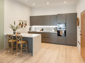 A kitchen with a counter and bar stools at tbc in St. Ives