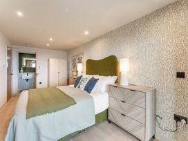 A bedroom with a bed and dresser at tbc in St. Ives