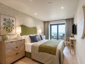 A bedroom with a bed and balcony door at tbc in St. Ives