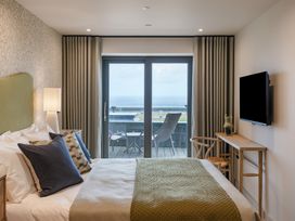 A bedroom with a bed, television, and sliding door at tbc in St. Ives