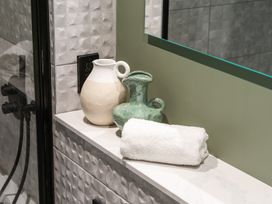 A bathroom counter with a towel and decorative vases at tbc in St. Ives