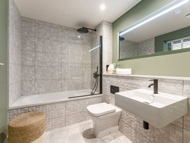 A bathroom with a bathtub, shower, toilet, and sink at tbc in St. Ives
