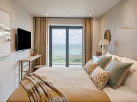 A bedroom with a bed and window overlooking the sea at The Old Barn in St. Ives