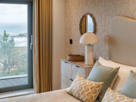 A bedroom with a bed, pillows, and a lamp at tbc in St. Ives