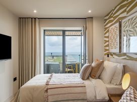 A bedroom with a bed and balcony view at tbc in St. Ives