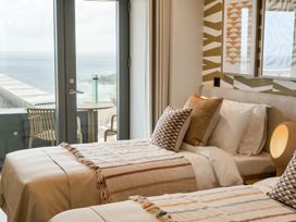 A bedroom with two beds and a view of the ocean at tbc St. Ives
