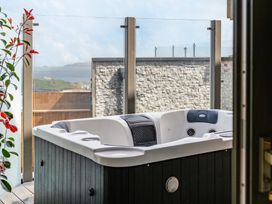 An outdoor area with a hot tub and glass railing at tbc in St. Ives