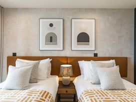 A bedroom with twin beds and framed art at tbc St. Ives