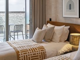 A bedroom with twin beds and a view at tbc in St. Ives