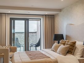 A bedroom with a bed and chairs at tbc in St. Ives