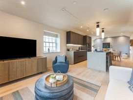 A living room with a tv, sofa and kitchen area at tbc in St. Ives