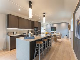 A kitchen with bar stools, a dining table, and various appliances at tbc in St. Ives