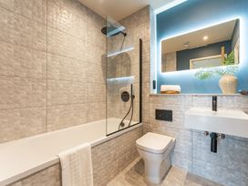 A bathroom with a bathtub, shower, toilet, and sink at tbc in St. Ives