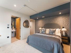 A bedroom with a bed and a door leading to a bathroom at tbc St. Ives