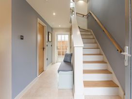 A hallway with a staircase and a bench at tbc in St. Ives