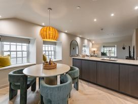 A dining room with a table and chairs and a kitchen island at tbc in St. Ives