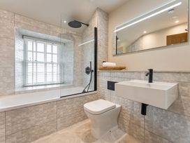 A bathroom with a bathtub, shower, toilet, and sink at tbc St. Ives