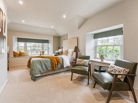 A bedroom with a bed and chairs at tbc in St. Ives