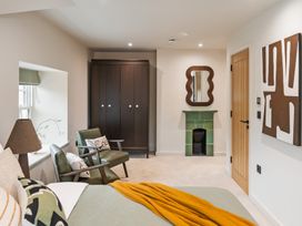 A bedroom with a bed, wardrobe, and chair at tbc in St. Ives