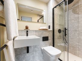 A bathroom with a sink, toilet, shower and mirror at tbc in St. Ives