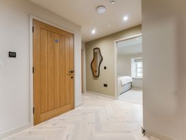 A hallway with a door, mirror, and thermostat at tbc in St. Ives