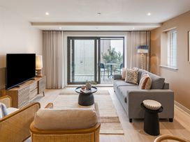 A living room with a television and sliding door to the balcony at tbc St. Ives