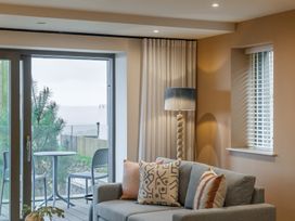 A living room with a sofa and table by a window at tbc in St. Ives
