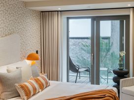 A bedroom with a bed and sliding door to balcony at tbc in St. Ives