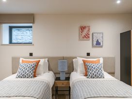 A bedroom with two beds and paintings at tbc in St. Ives