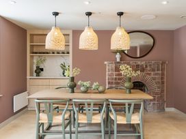 A dining room with a table, chairs, and a fireplace at Hidden 16- Garden Apartment St Ives