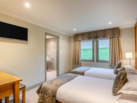 A bedroom with two beds and a desk at The Derwent Spa (Pet) in Slaley