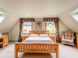 A bedroom with a bed and armchair at The Derwent Spa (Pet) Slaley
