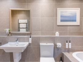 A bathroom with a sink, toilet, mirror, and towel rack at The Derwent Spa (Pet) Slaley