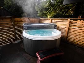 A hot tub with water and a cover in an outdoor space at Sidlaw Spa (Pet) Fowlis near Dundee