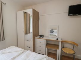 A bedroom with a desk and wardrobe at 7 Blue Water, Bournemouth