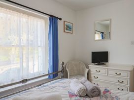 A bedroom with a bed, television, window and dresser at Morpeth in Combe St Nicholas
