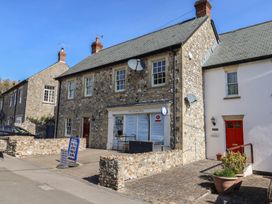 A shop front with stone building and windows at The Village Shop in Combe St Nicholas