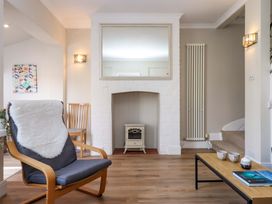A living room with an armchair and a fireplace at Kents Cottage in Torquay