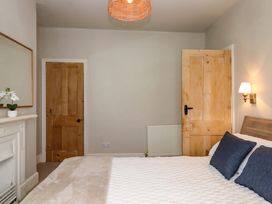 A bedroom with a bed and a lamp at Kents Cottage in Torquay