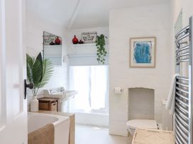 A bathroom with a bathtub, sink, and toilet at Kents Cottage in Torquay