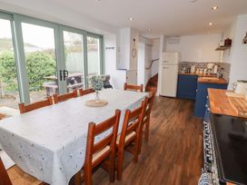 A kitchen with a dining table and refrigerator at No.8 Millmoor Farm Cottage Broad Haven