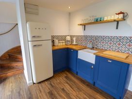 A kitchen with a fridge, sink, and countertop at No.8 Millmoor Farm Cottage in Broad Haven