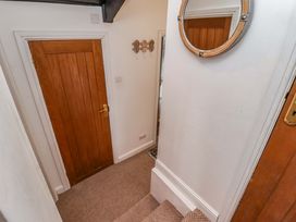 A hallway with a door and mirror at No.8 Millmoor Farm Cottage in Broad Haven