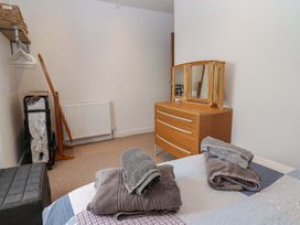 A bedroom with a bed and dresser at No.8 Millmoor Farm Cottage in Broad Haven