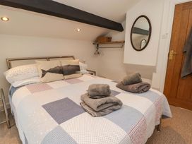 A bedroom with a bed and towels at No.8 Millmoor Farm Cottage in Broad Haven